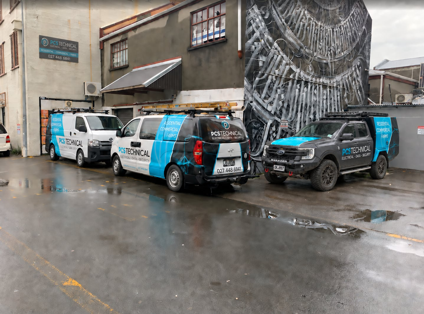 PCS Technical-branded vehicles and technicians at a service station forecourt